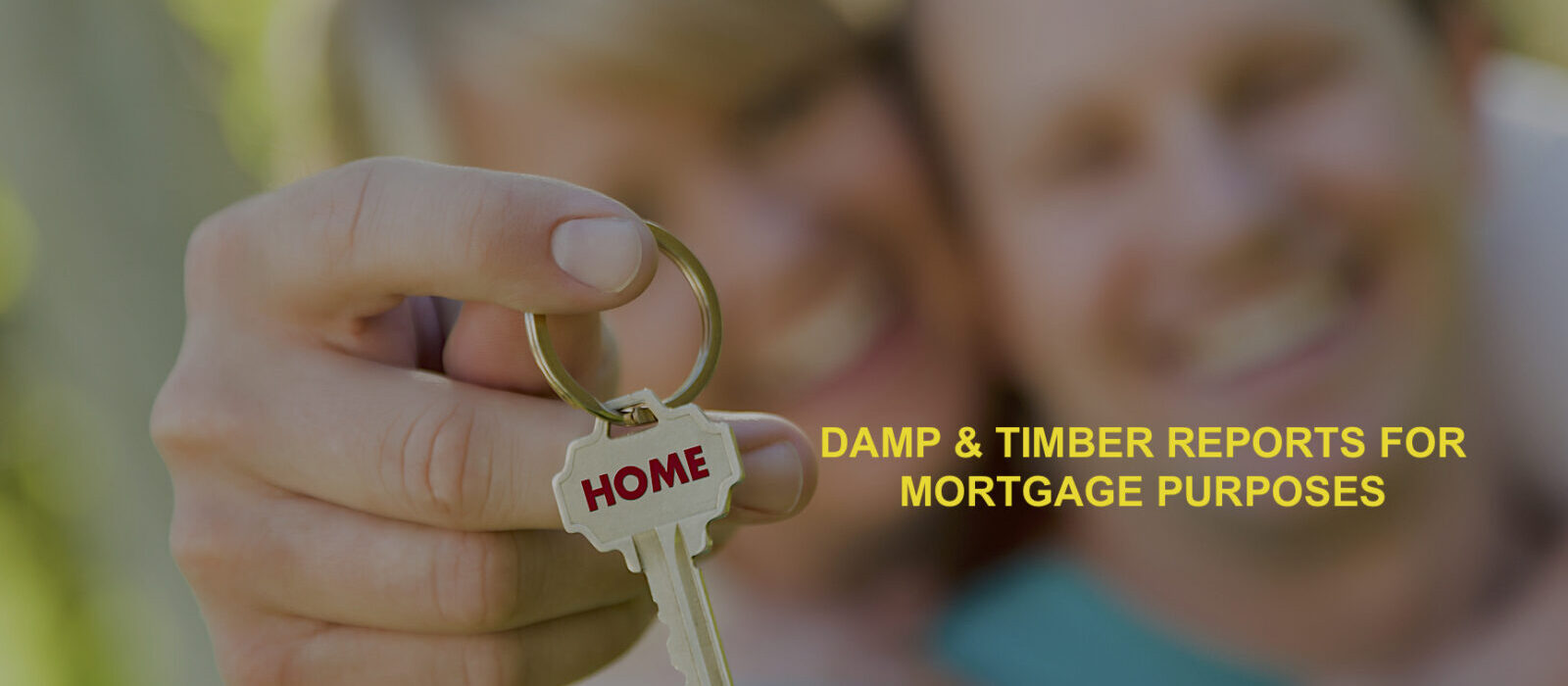 Happy Couple Holding House Key with Home Text On The Key.