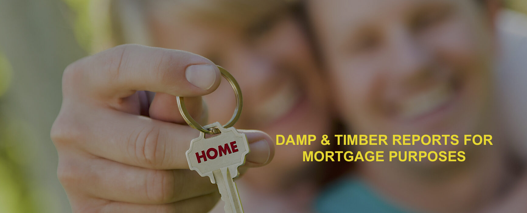 Happy Couple Holding House Key with Home Text On The Key.